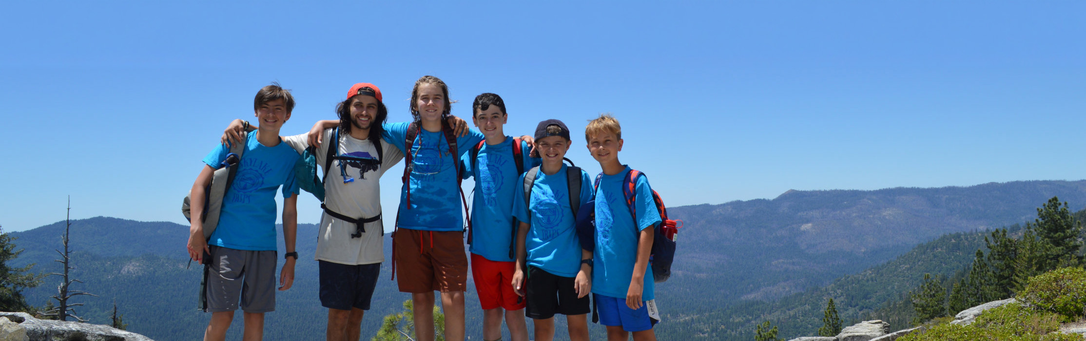 Boys standing on a rock at the top of yosemite