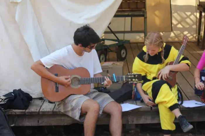 Campers strumming guitars