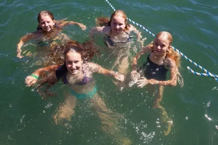 Four girls swimming in lake